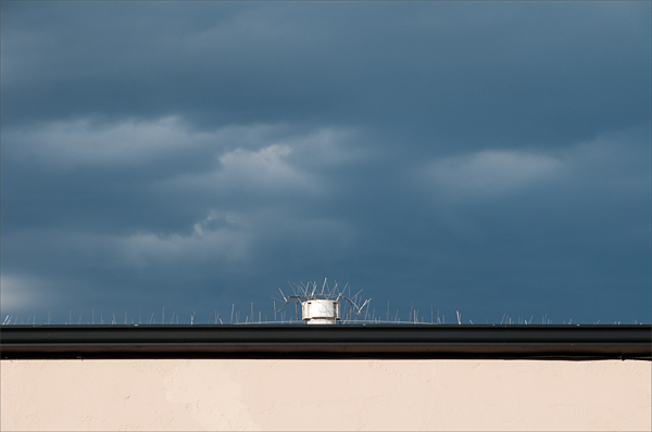 The edge of a rooftop against an oncoming storm.